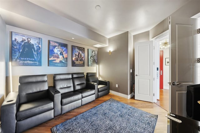 home theater room featuring wood finished floors and baseboards