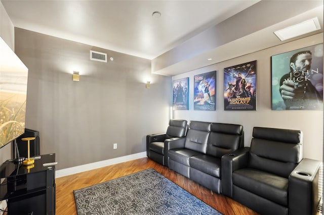 home theater with visible vents, baseboards, and wood finished floors