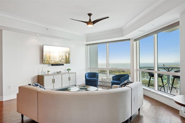 living room with hardwood / wood-style floors, a ceiling fan, baseboards, floor to ceiling windows, and crown molding