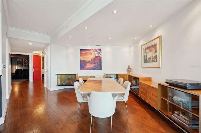 dining area with dark wood finished floors, crown molding, and recessed lighting