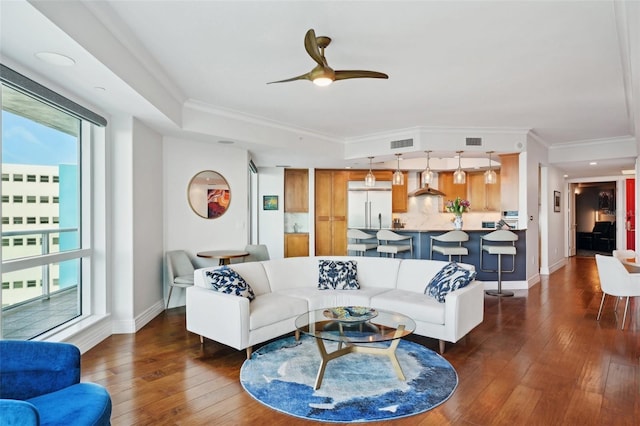 living room featuring crown molding, dark wood-style floors, visible vents, and baseboards