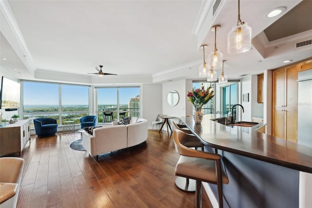 interior space featuring visible vents, dark wood finished floors, a tray ceiling, ceiling fan, and crown molding