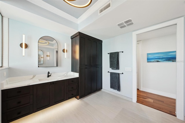 bathroom featuring vanity, wood finished floors, baseboards, and visible vents