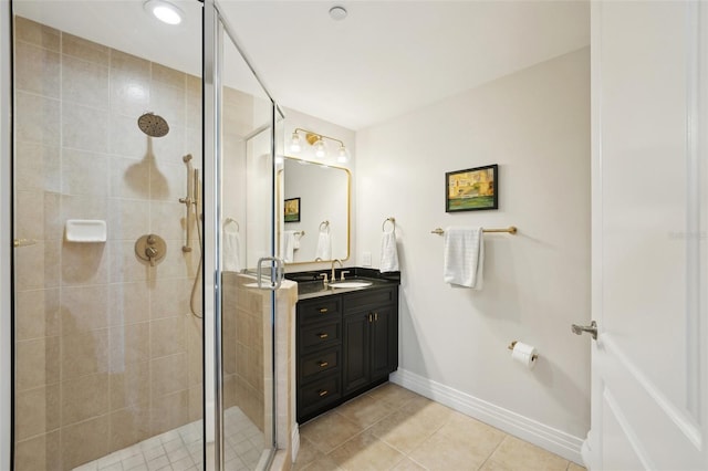 bathroom featuring tile patterned floors, baseboards, vanity, and a shower stall