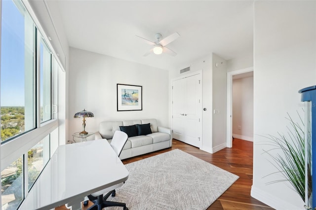 home office with ceiling fan, visible vents, baseboards, and wood finished floors