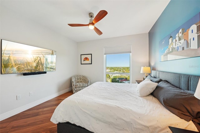 bedroom with a ceiling fan, baseboards, and wood finished floors