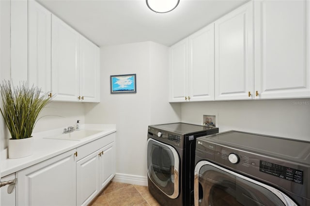 laundry room featuring baseboards, washing machine and dryer, light tile patterned flooring, cabinet space, and a sink