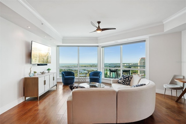 living area with crown molding, ceiling fan, baseboards, and hardwood / wood-style flooring