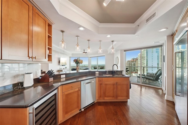 kitchen with visible vents, a tray ceiling, dishwasher, beverage cooler, and a sink