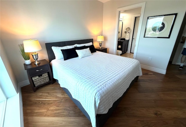 bedroom with wood finished floors, baseboards, and ensuite bathroom