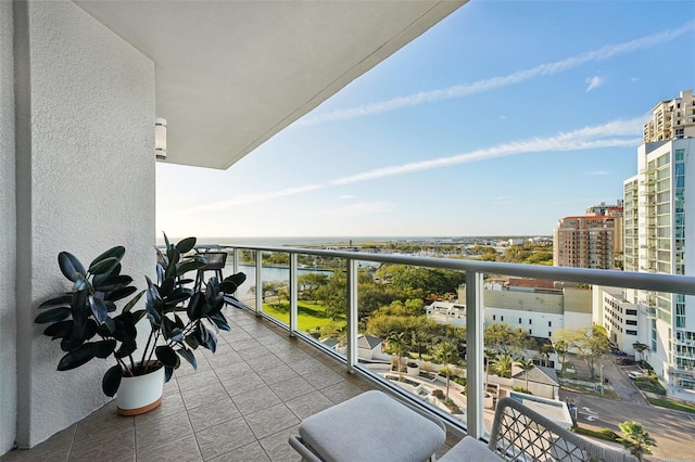 balcony with a water view and a view of city