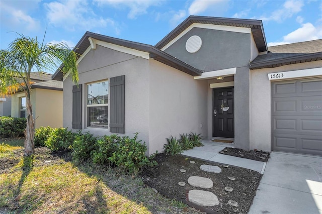 property entrance featuring an attached garage and stucco siding