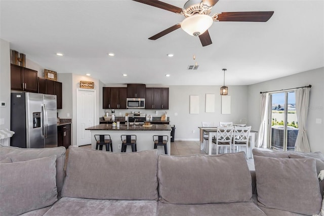 living area with ceiling fan, visible vents, baseboards, and recessed lighting