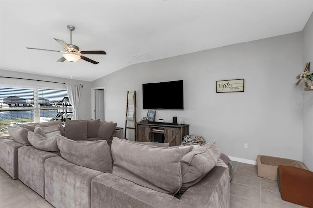 living room featuring light tile patterned floors, baseboards, ceiling fan, a water view, and vaulted ceiling