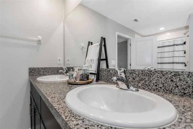 bathroom featuring a shower with curtain, visible vents, a sink, and double vanity