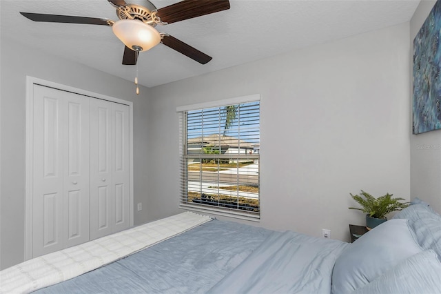 bedroom with a ceiling fan and a closet