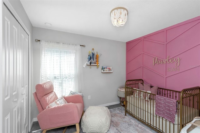 bedroom featuring a nursery area, baseboards, and a closet