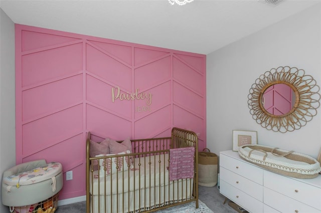 carpeted bedroom featuring a nursery area