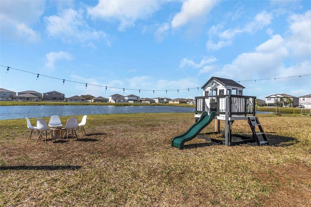 community jungle gym with a water view, a residential view, and a lawn