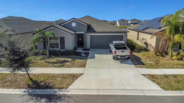 ranch-style home with a garage, concrete driveway, roof with shingles, and stucco siding