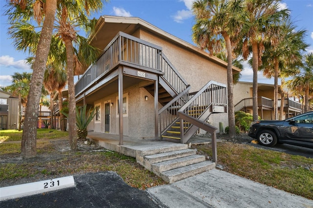 view of property featuring stairway and stucco siding