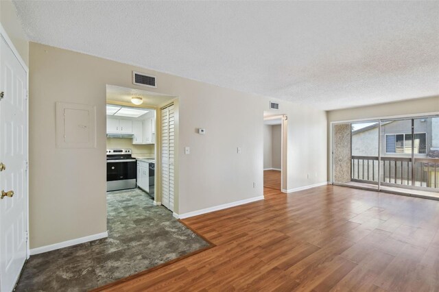 living room featuring baseboards, a textured ceiling, visible vents, and wood finished floors