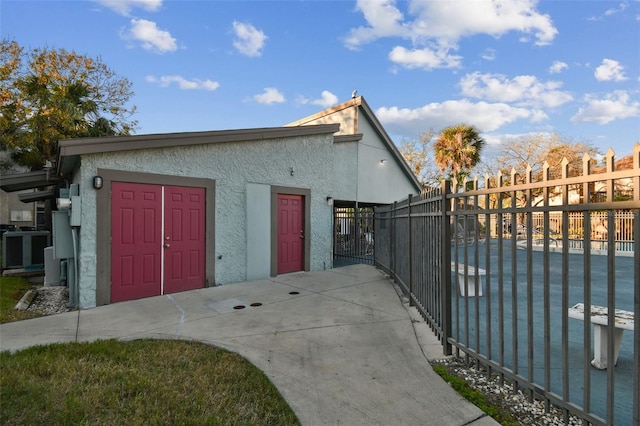 exterior space featuring fence, a gate, and stucco siding