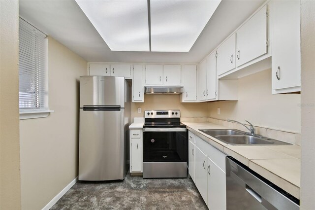 kitchen with baseboards, stainless steel appliances, under cabinet range hood, white cabinetry, and a sink