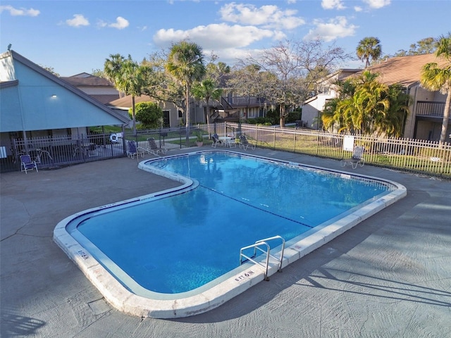 pool with a patio and fence
