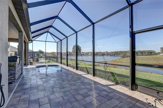 view of pool with a lanai, a patio area, a water view, and a hot tub