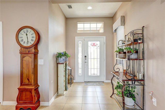 entrance foyer with a wealth of natural light, light tile patterned flooring, and baseboards