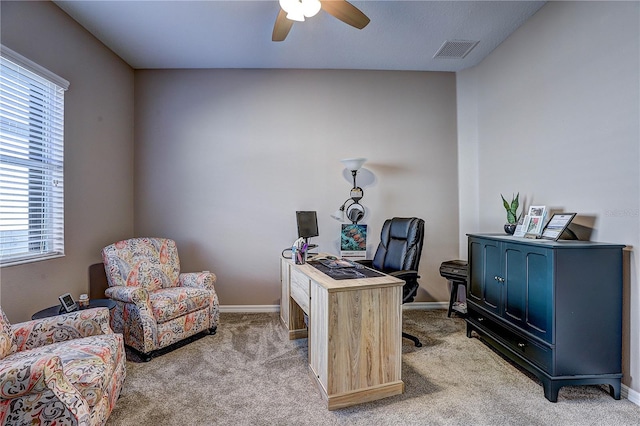 office space featuring light carpet, baseboards, visible vents, and ceiling fan