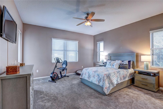 bedroom with a textured ceiling, carpet floors, a ceiling fan, and baseboards