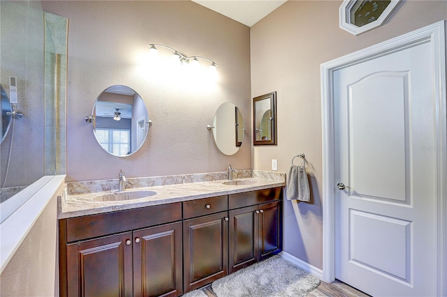 bathroom featuring a sink, baseboards, and double vanity