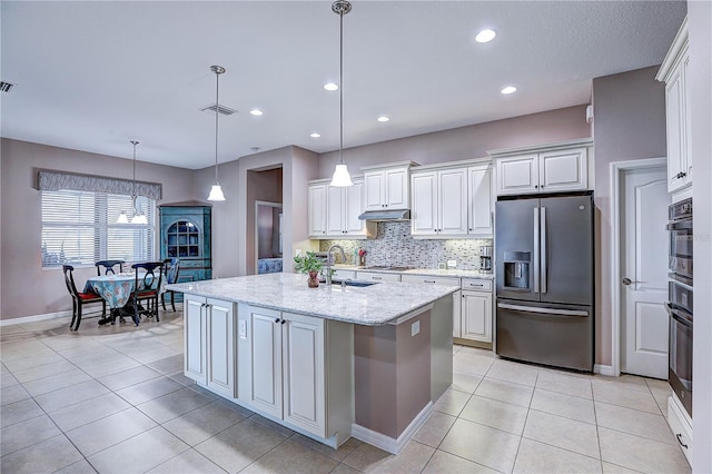 kitchen with oven, a sink, visible vents, stainless steel refrigerator with ice dispenser, and tasteful backsplash