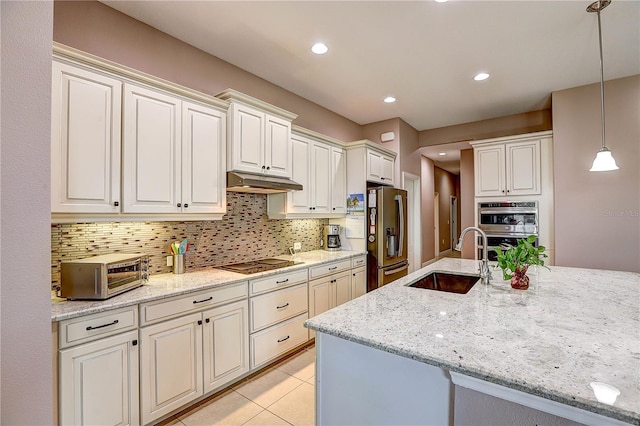 kitchen featuring a toaster, stainless steel appliances, decorative backsplash, a sink, and under cabinet range hood