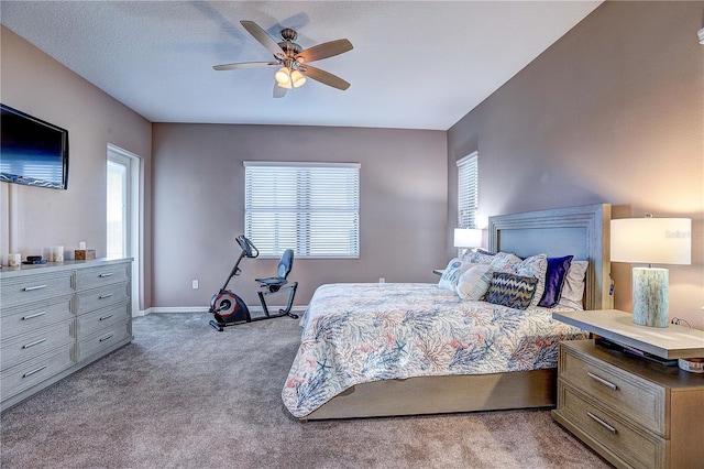 carpeted bedroom featuring ceiling fan, a textured ceiling, and baseboards