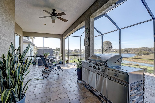 sunroom with a water view and ceiling fan