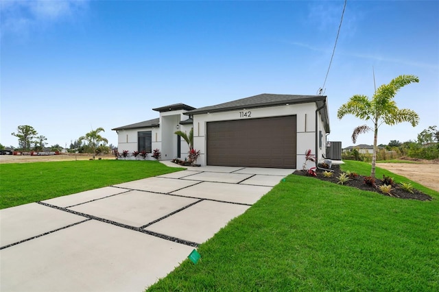 view of front of house with concrete driveway, a front lawn, an attached garage, and stucco siding