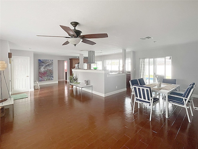 dining room with ceiling fan, baseboards, visible vents, and dark wood finished floors