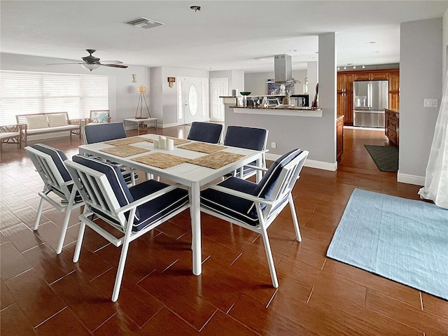 dining space with dark wood-style floors, ceiling fan, visible vents, and baseboards