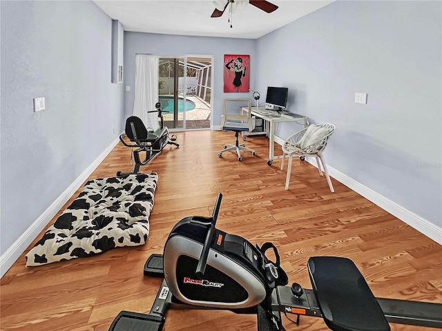 workout room with ceiling fan, baseboards, and wood finished floors