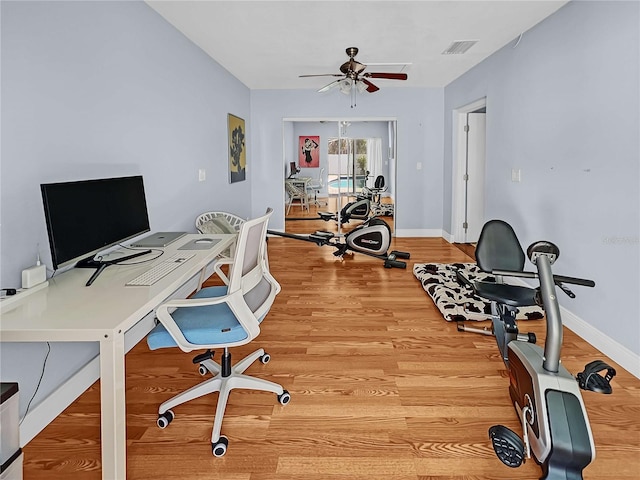 office with light wood finished floors, baseboards, visible vents, and a ceiling fan