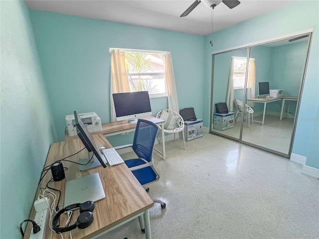 office featuring a ceiling fan, plenty of natural light, baseboards, and speckled floor