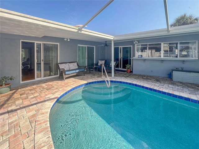 outdoor pool with glass enclosure, outdoor lounge area, a patio area, and a ceiling fan