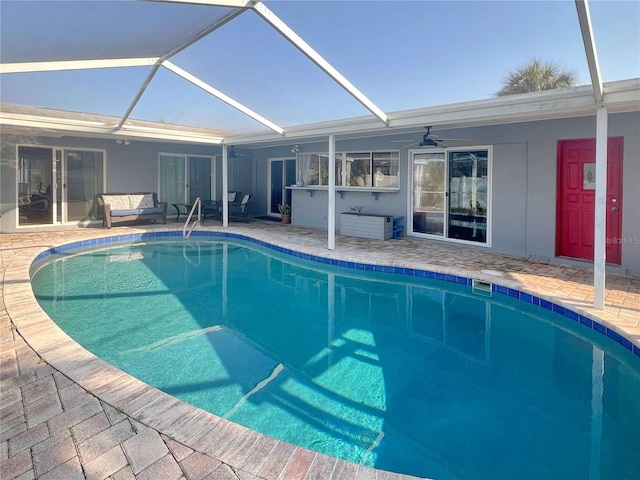 pool with a patio, glass enclosure, an outdoor living space, and a ceiling fan