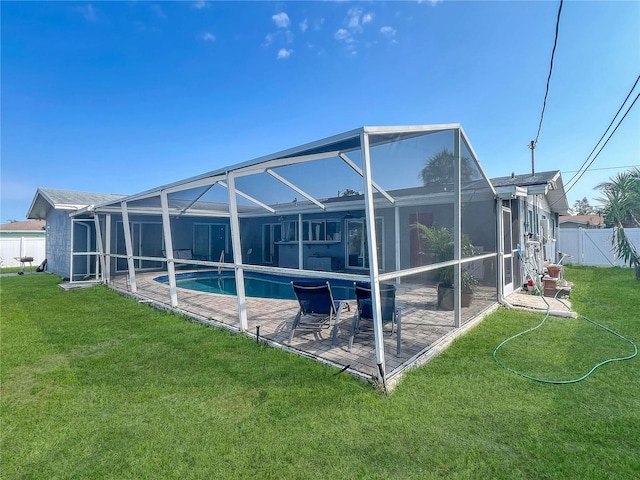 back of house with a lanai, fence, a lawn, a fenced in pool, and a patio area