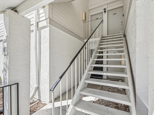 stairs featuring a textured wall