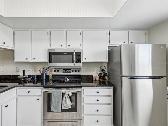 kitchen with dark stone counters, appliances with stainless steel finishes, and white cabinets