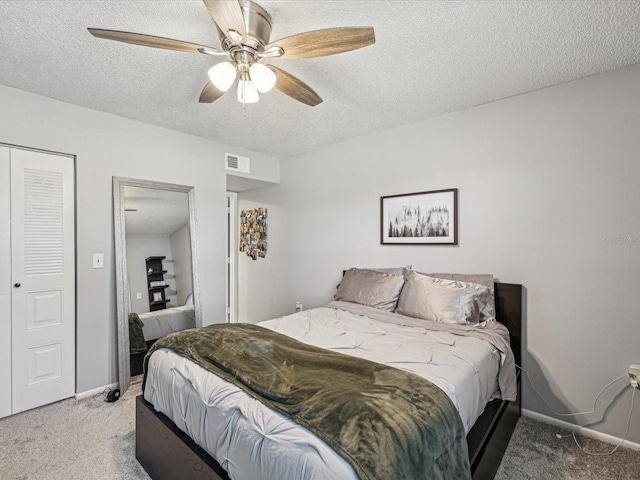 bedroom with carpet, visible vents, a textured ceiling, and baseboards